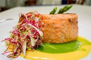 Trancio di salmone grigliato con asparagi e insalata di germogli su crema di piselli