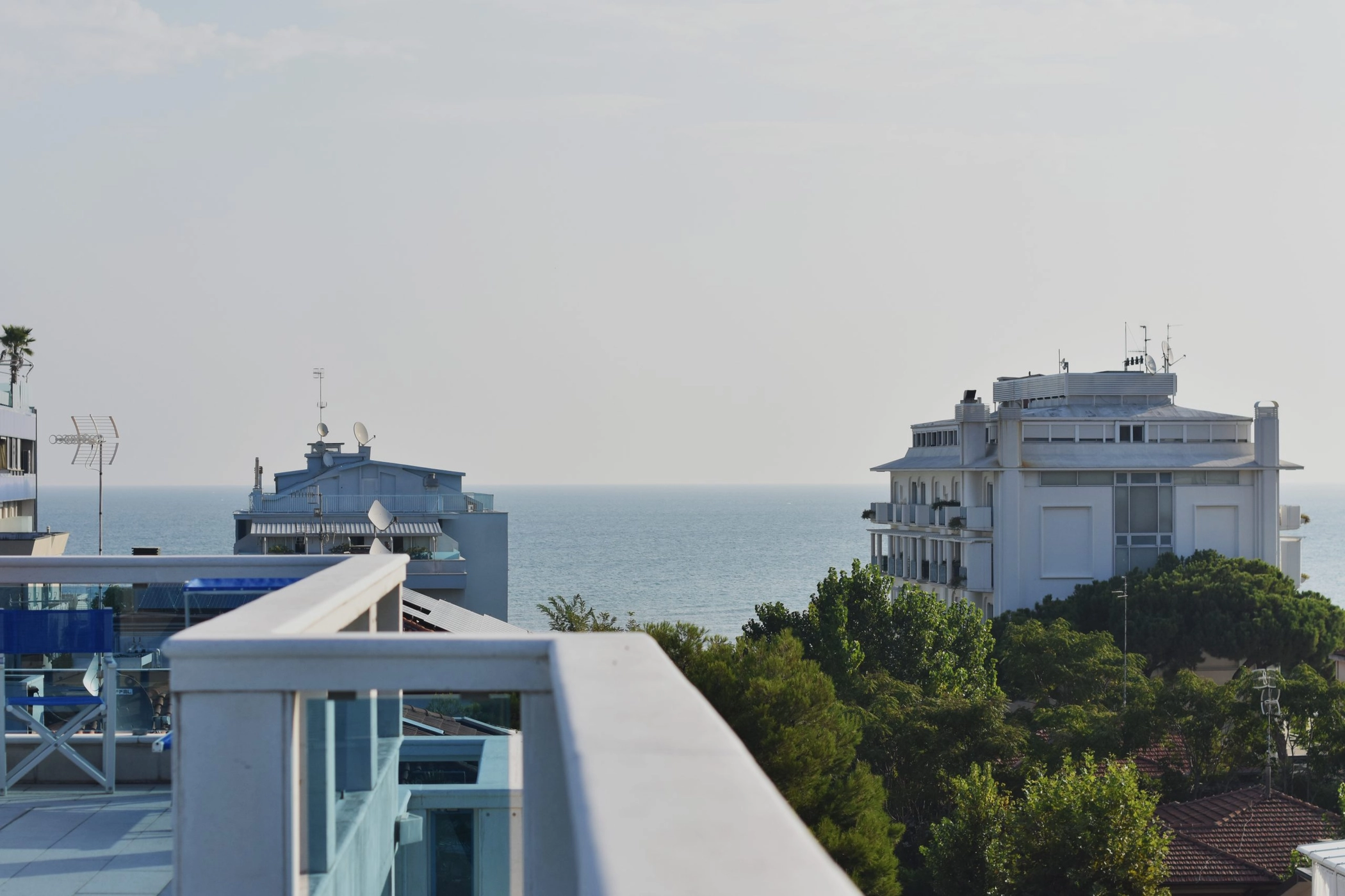 Il mare di Riccione visto dalla terrazza dell’hotel, tra i palazzi e il verde