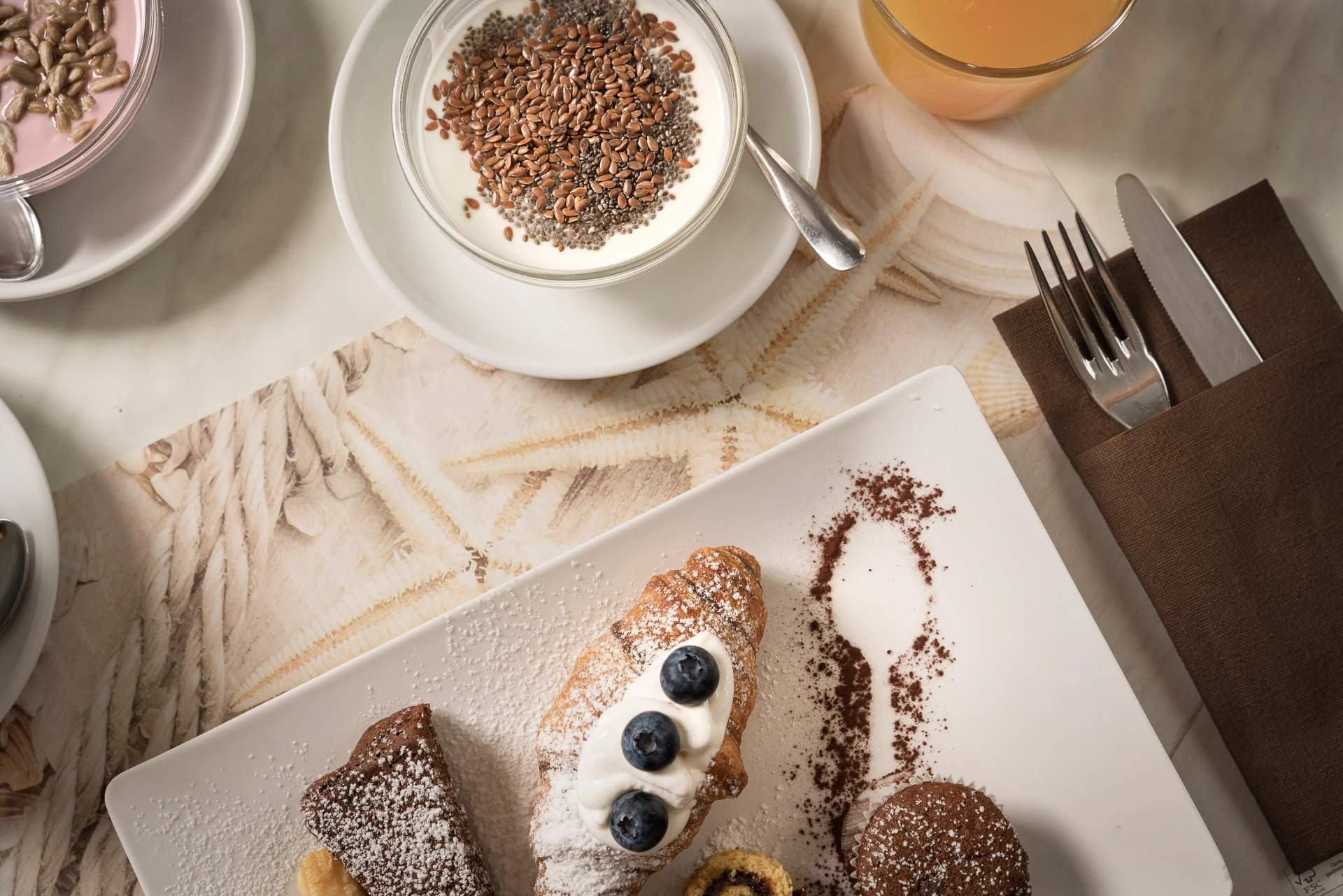 Yogurt con cereali, frutta e dolci sul tavolo della colazione