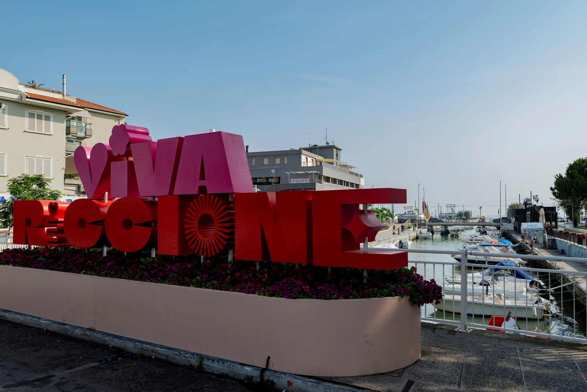 La grande scritta rossa «Viva Riccione» sul lungomare, davanti al porto