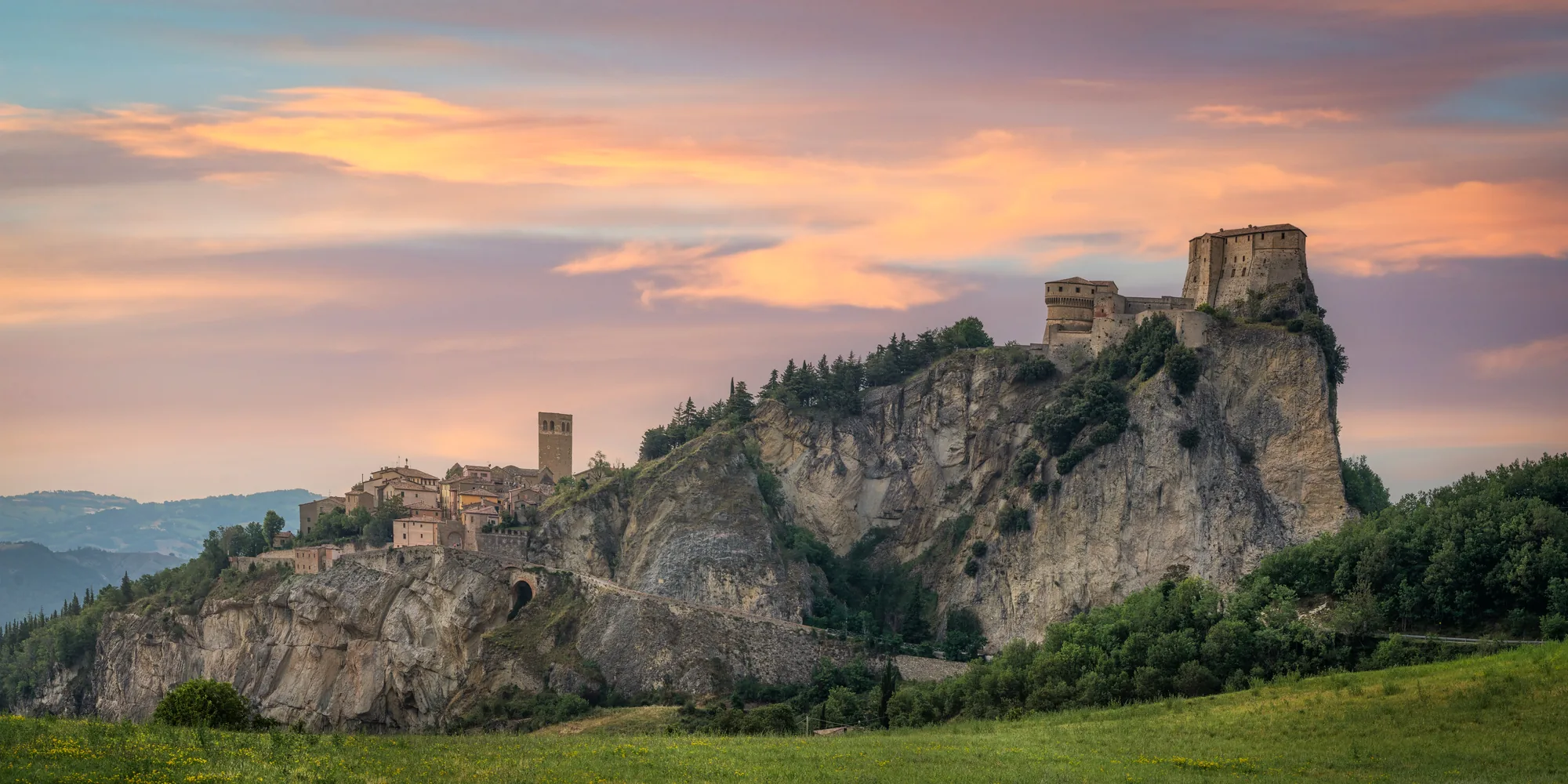 La fortezza di San Leo sulla rupe e il borgo, al tramonto